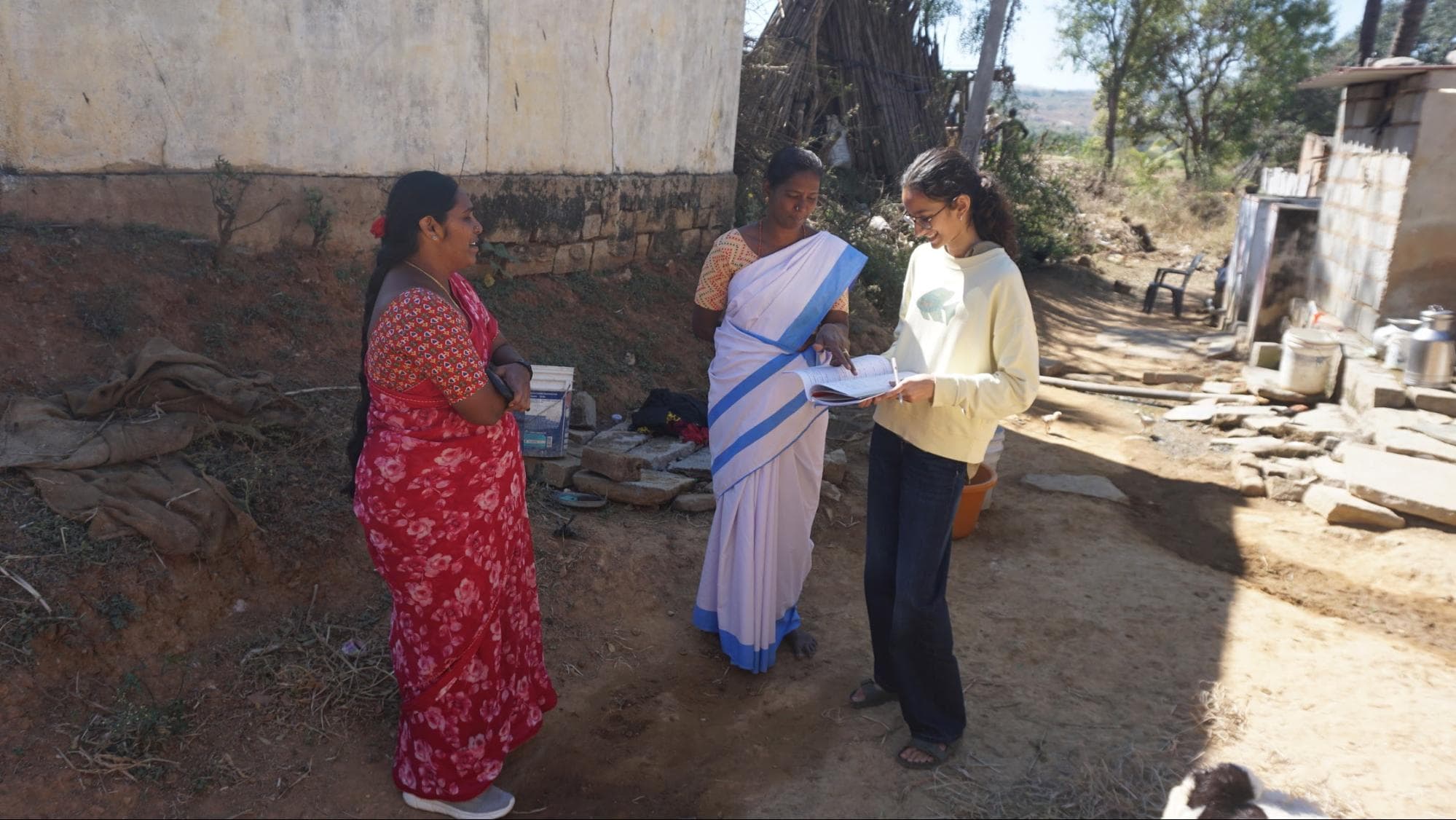 An ASHA worker, in the white saree, detailing the nature of her work